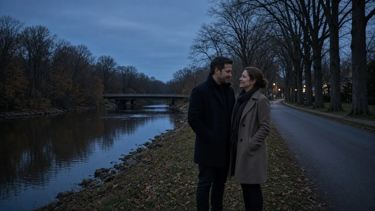 A dressed couple in coats beside a river at dusk, no signs.