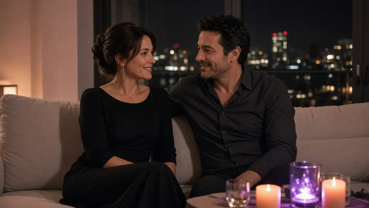 A dressed couple on a sofa at night, talking close, peach and purple candlelight around them.